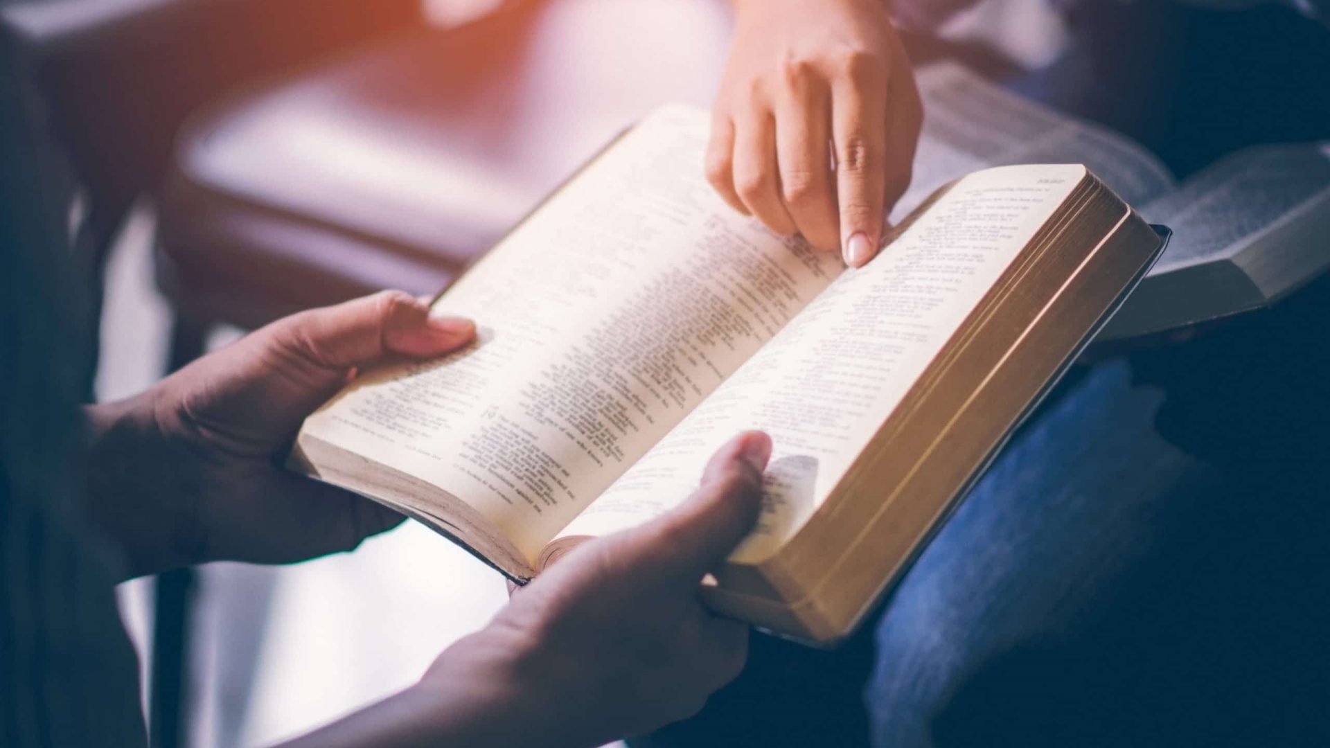 Male adults are reading the Holy bible by pointing to the character and to share the gospel to youth. The cross symbol, The books of the Bible, Concepts of Christianity.